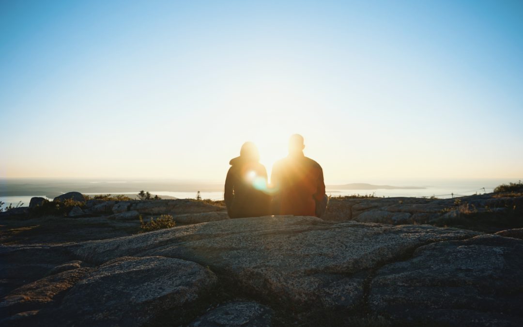 silhouette of couple with sunlight shining through between them
