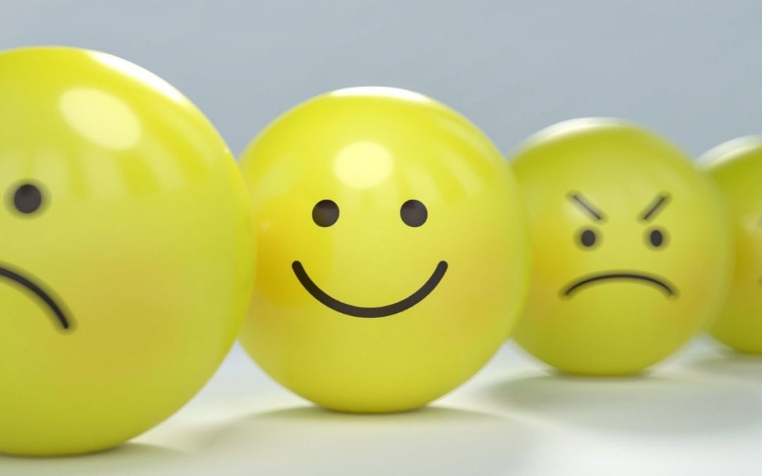 yellow smiley face ball among sad and angry balls representing service to others