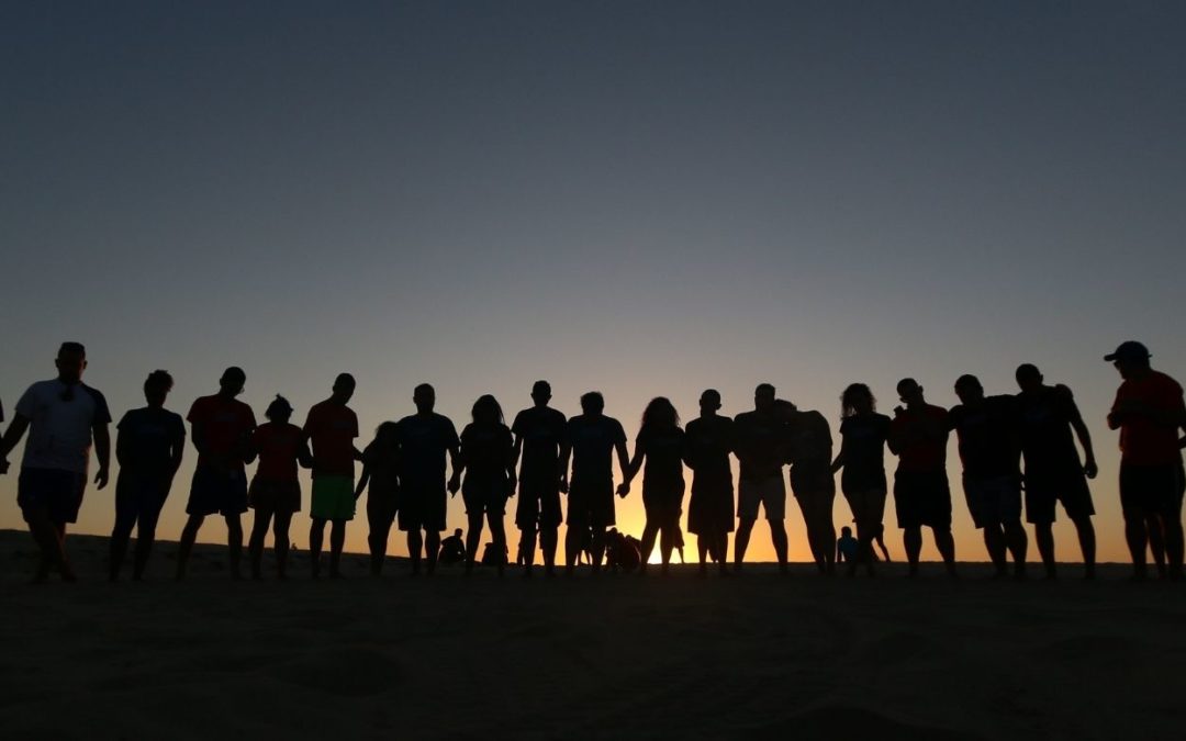 group of people holding hands on the horizon symbolizing the fact that you are never alone