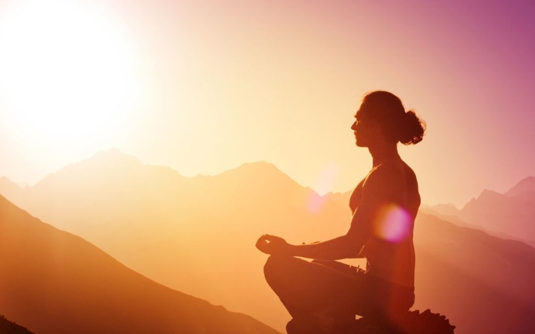 Man meditating at sunrise representing connecting with the Arcturians