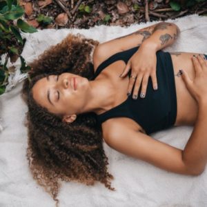 woman lying down meditating representing going within