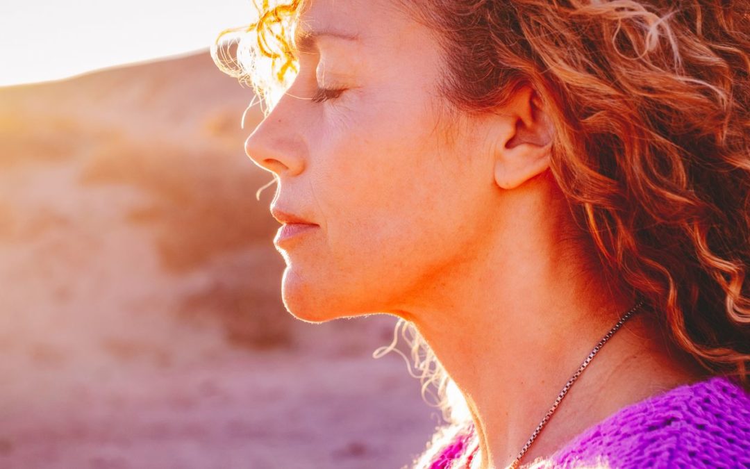woman in sunshine with eyes closed representing meditation practice for simple energy boost