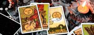 Tarot cards and a candle representing fate vs ego and discernment